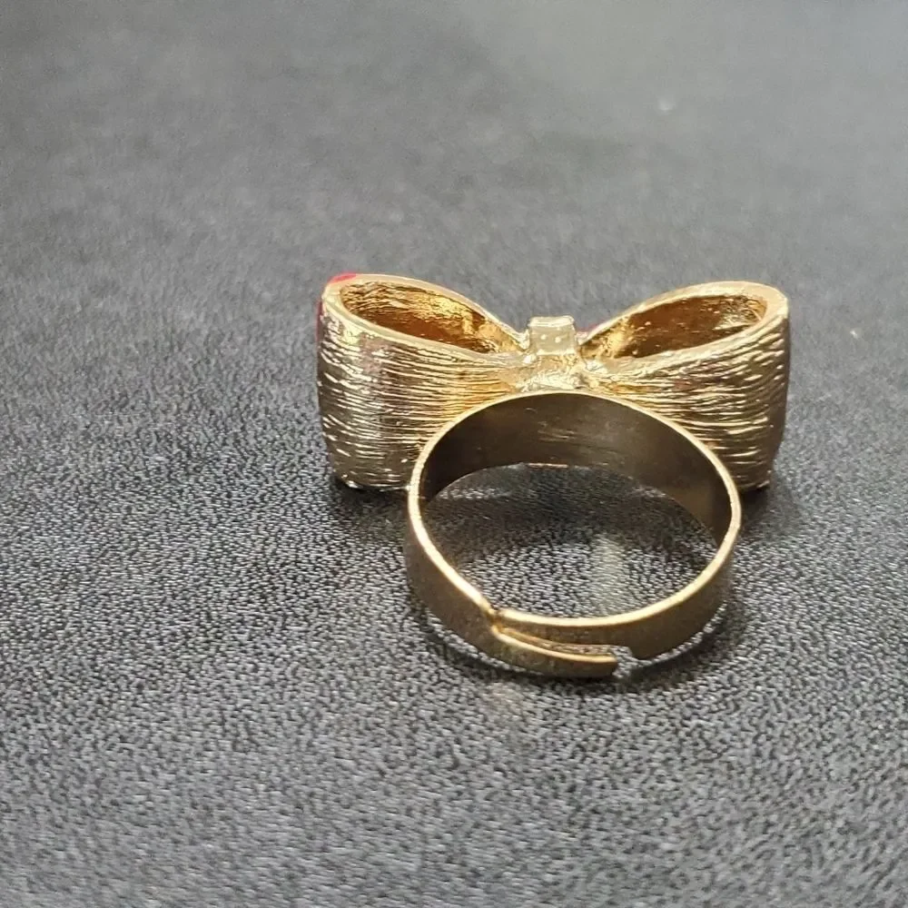 Gold tone red enamel bow ring currently a 7